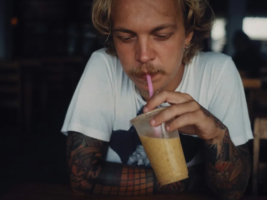 Man drinkt een smoothie met een rietje