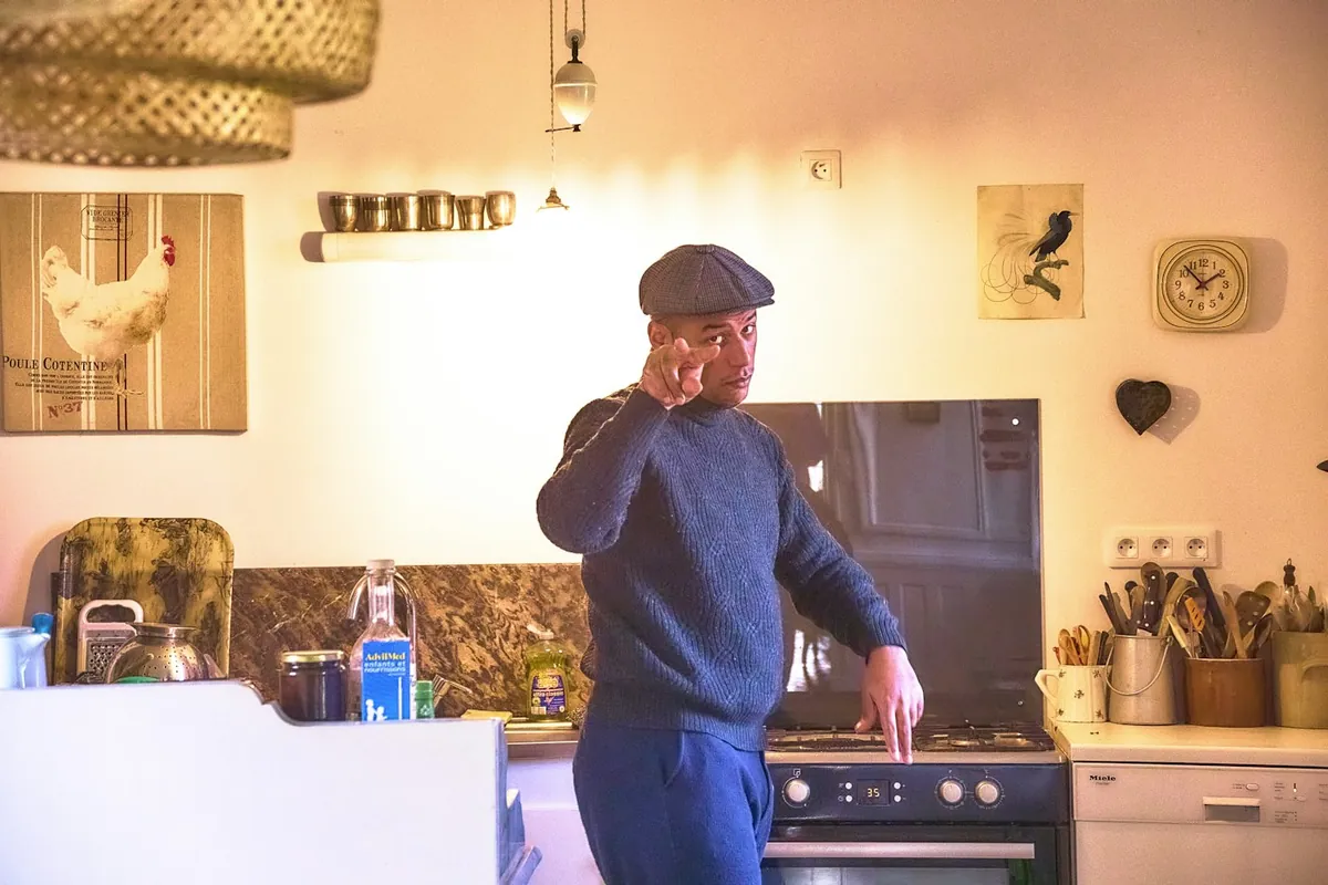 Man met pet belt in zijn keuken