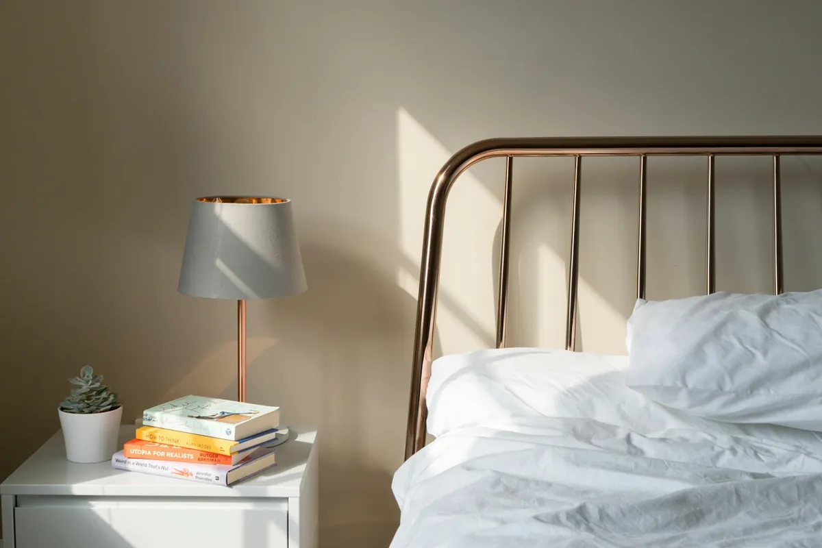 Opgemaakt bed met een lampje op het nachtkastje
